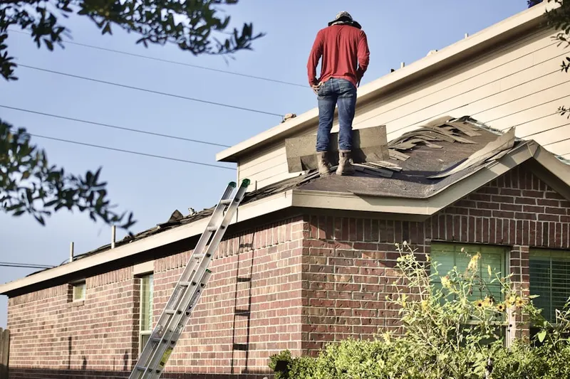 Professional roofer working on a residential roof in Noble